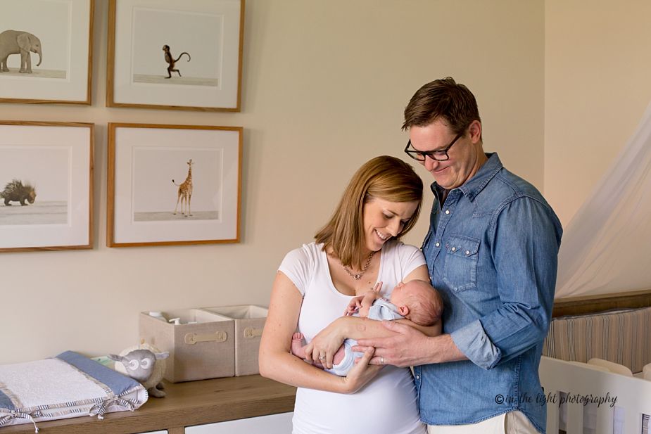 parents and newborn baby in his nursery