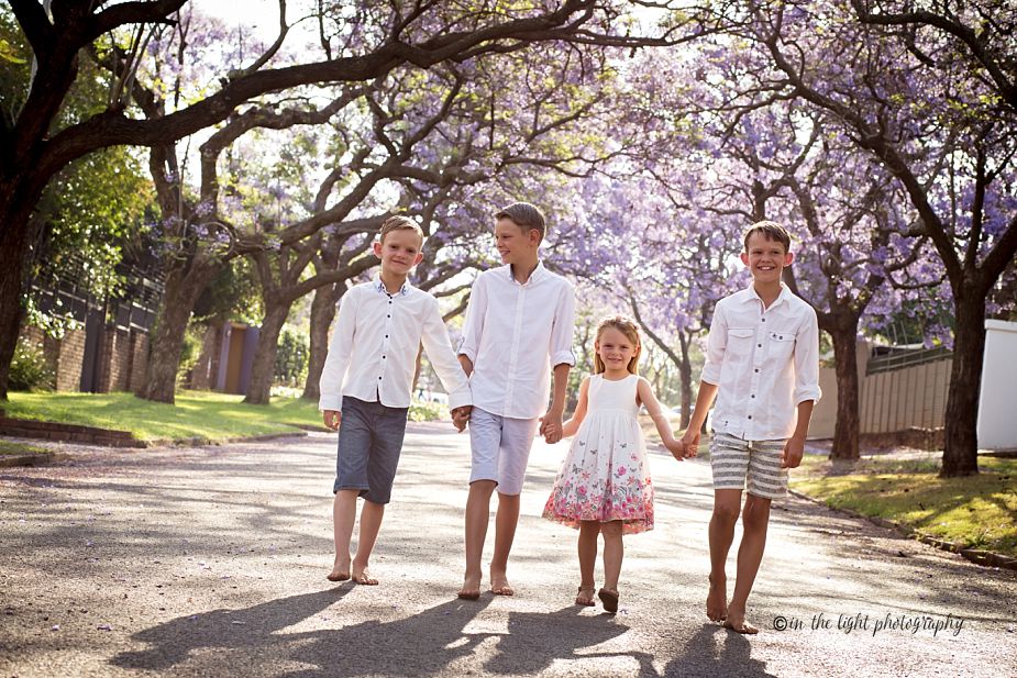 jacaranda lined street with a family