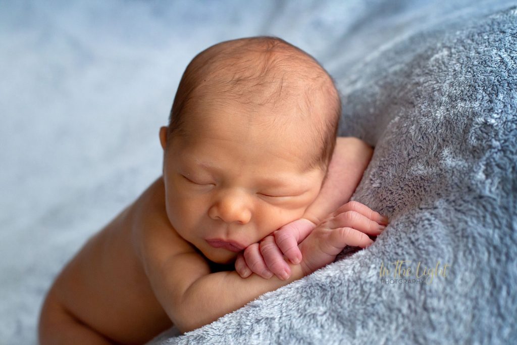 Newborn baby boy lying on a blue soft blanket during his newborn session in Centurion.