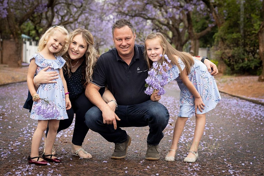 A family smiling during their Jacaranda photo session in Pretoria.